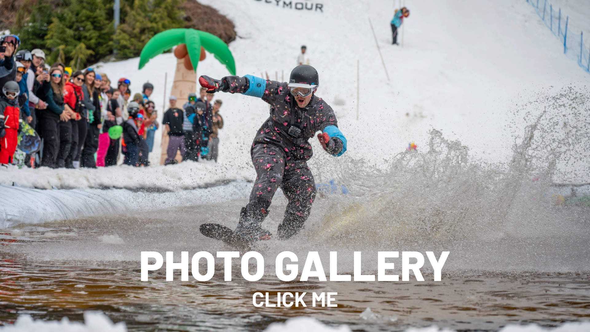 Snowboarder in a costume skimming over a pool with spectators watching.