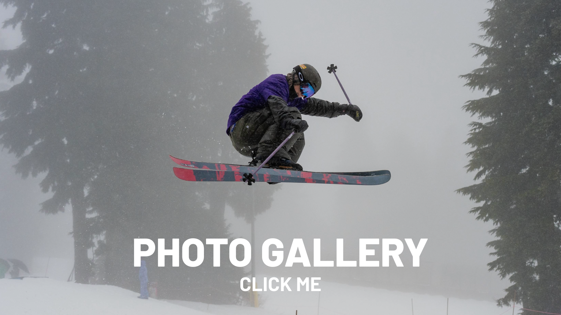 Skier airborne in foggy forest landscape.