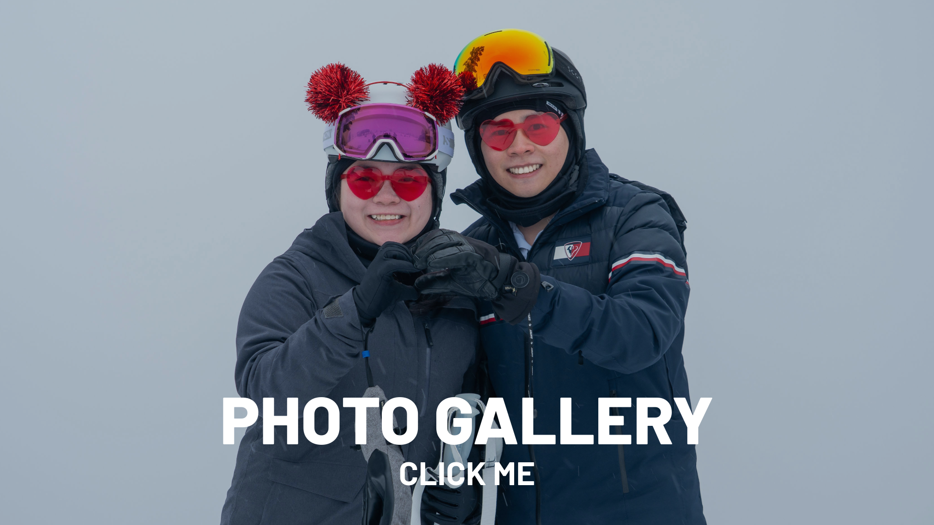 Two people in ski gear smiling on a snowy day.