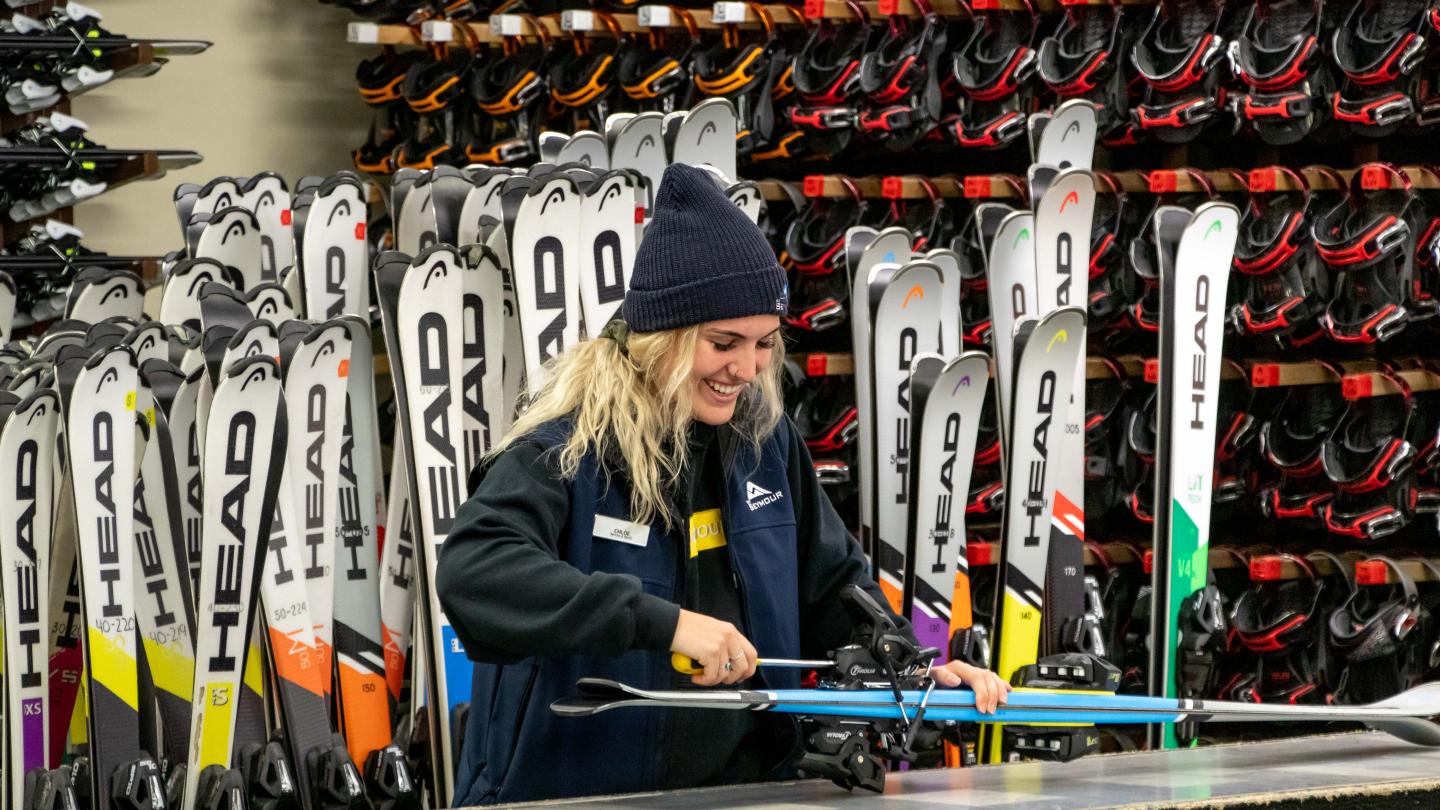 Rental staff fixing a pair of skis