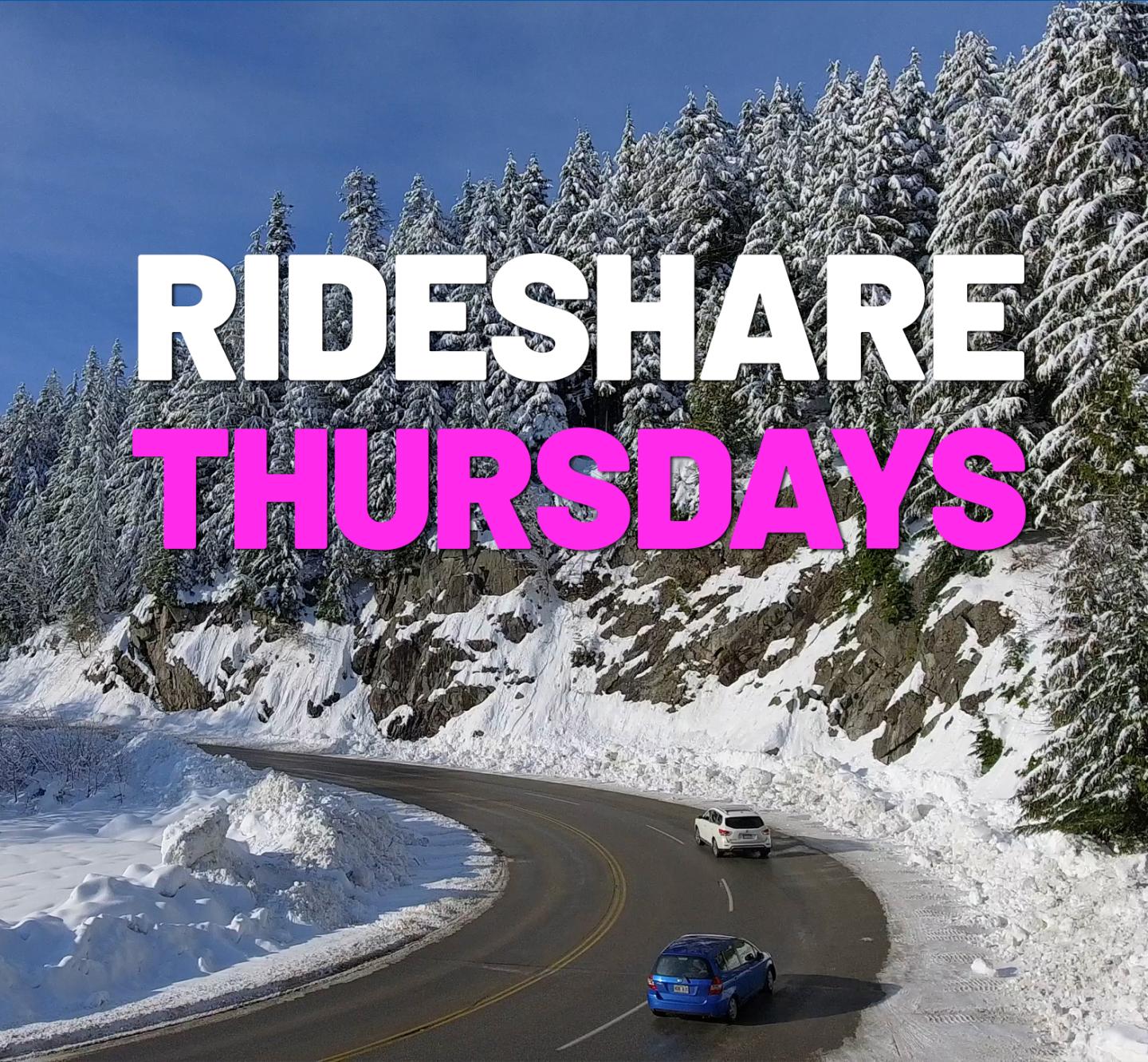 Snowy road with two cars, bordered by snow-covered trees under a clear blue sky.