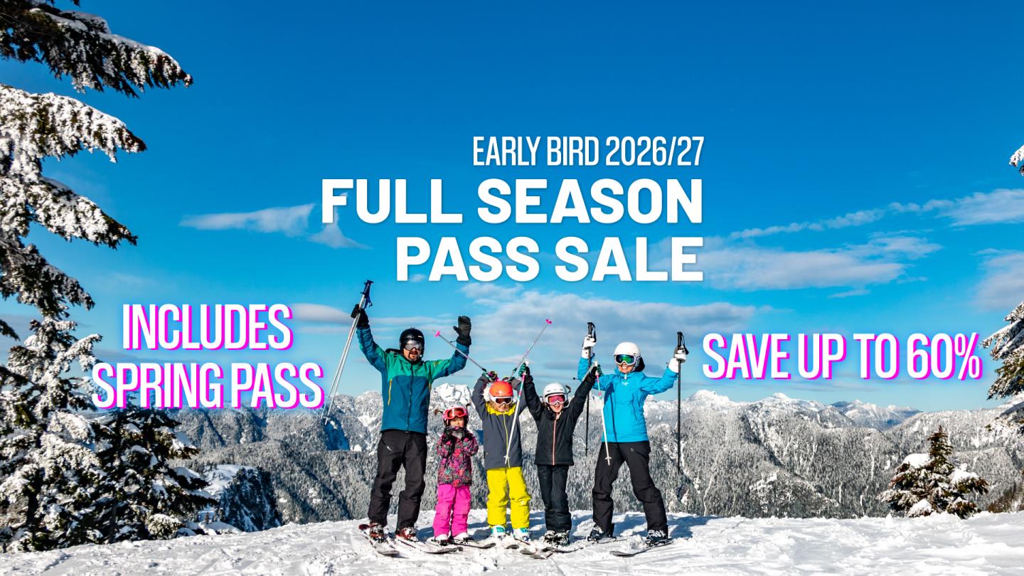 Skiers celebrating on snowy mountain under a clear blue sky.